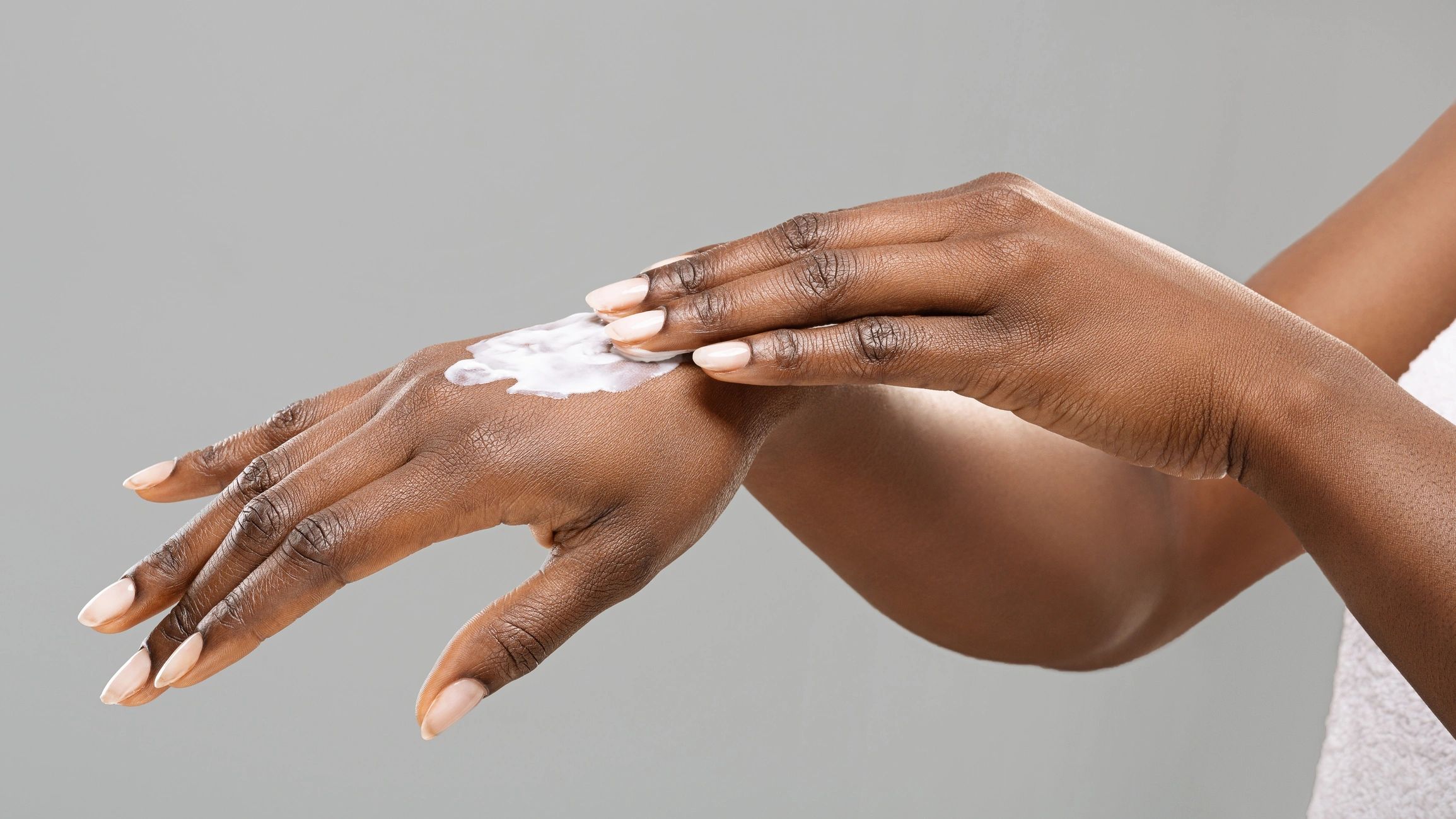Hands applying body lotion, close-up